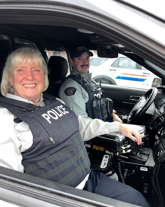 Cpl Madonna Saunderson in passenger seat of police vehicle while son, Cst John Saunderson sits in the driver's seat